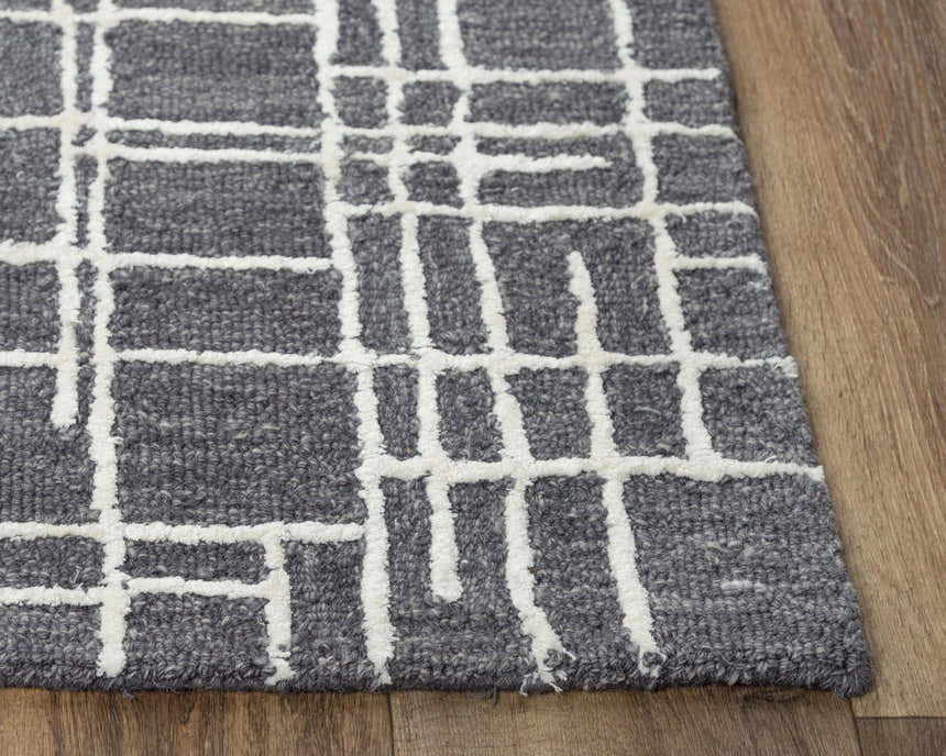 Close-up of the hand-tufted Rizzy JZZ971 area rug. Gray wool with an ivory geometric pattern. Contemporary style. Corner