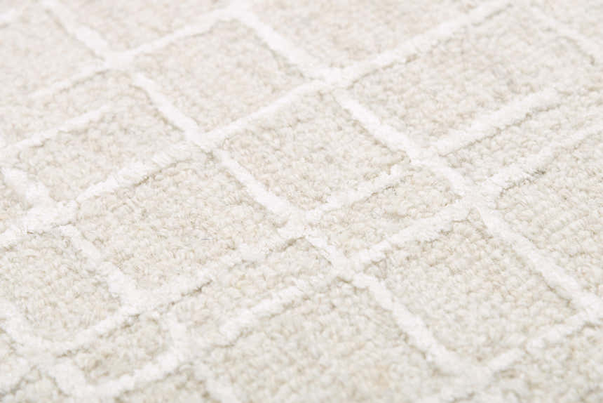 Close-up of the ivory Rizzy JZZ973 area rug. Features a hand-tufted, contemporary square pattern and wool texture. Texture