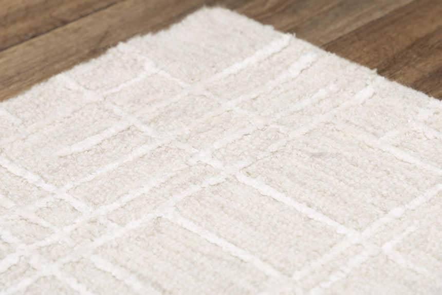 Close up of the ivory Rizzy JZZ973 area rug, a hand-tufted wool rug with a subtle geometric pattern. Texture