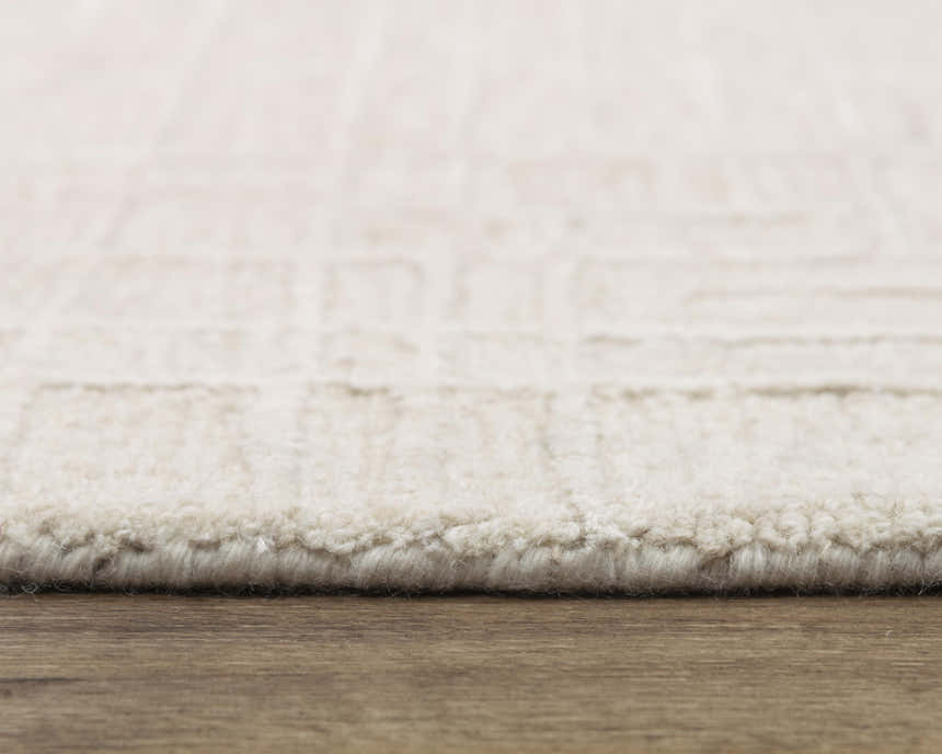 Close-up of the ivory Rizzy JZZ973 area rug showing its wool texture and subtle geometric pattern. Pile