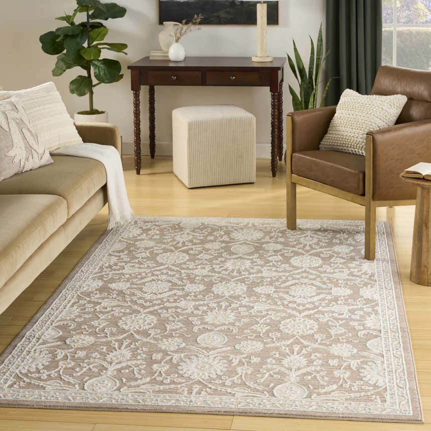Living room scene with a light brown Nourison Isla Mocha vintage rug, sofa, and leather chair.