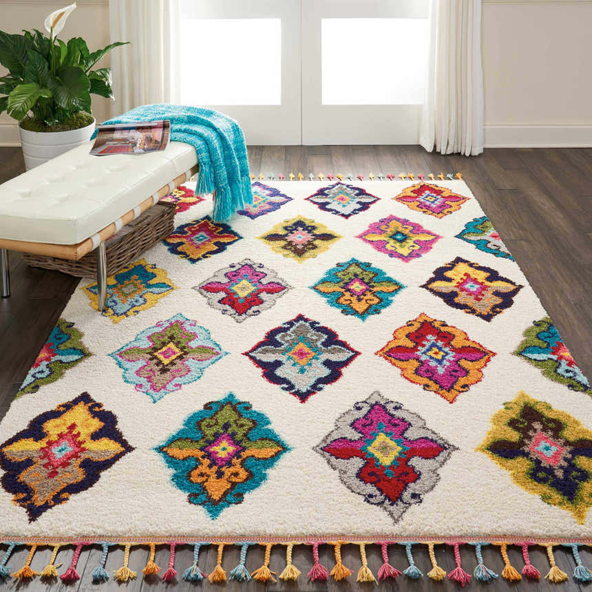 Living room scene with Nourison Nomad Ivory Multicolor Floral rug, white bench, wood floors, and bright, airy feel.