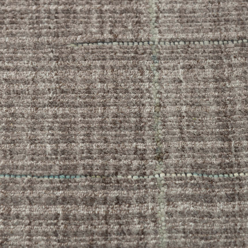 Close-up of the hand-loomed Rizzy KIK691 area rug. Gray wool and tencel blend with a subtle blue grid pattern. Soft texture. Texture