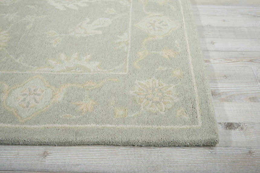 Close up of the Nourison Zephyr Light Taupe rug showing its wool texture and ivory floral pattern.