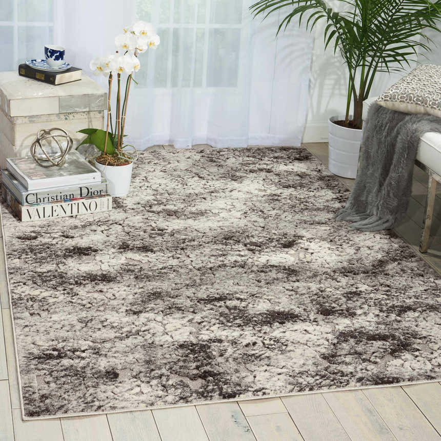 Living room scene with a Michael Amini Gleam Ash rug, white furniture, wood floors, and natural light.