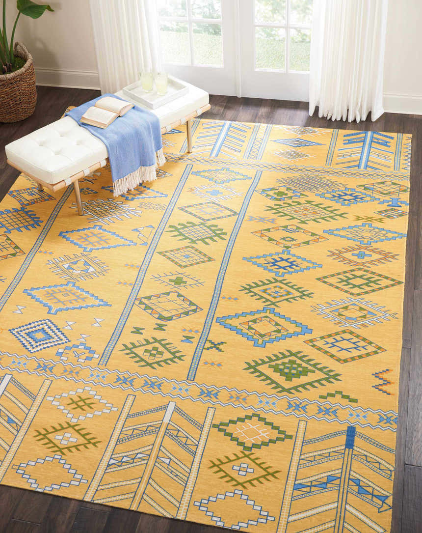 Bright living room with a Nourison Madera Saffron Tribal rug, white bench, and dark wood floors.