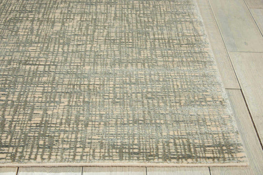 Close up of Nourison Starlight Sea Mist rug showing its light beige and gray grid pattern and soft texture.