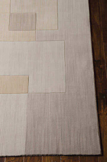 Close-up of the Calvin Klein Home Loom Select Neutrals Drift rug, featuring a geometric pattern in beige and tan on dark wood floors.