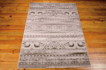 Close-up of Nourison Karma Beige Vintage Indoor Area Rug showing pattern and texture on wood floor.