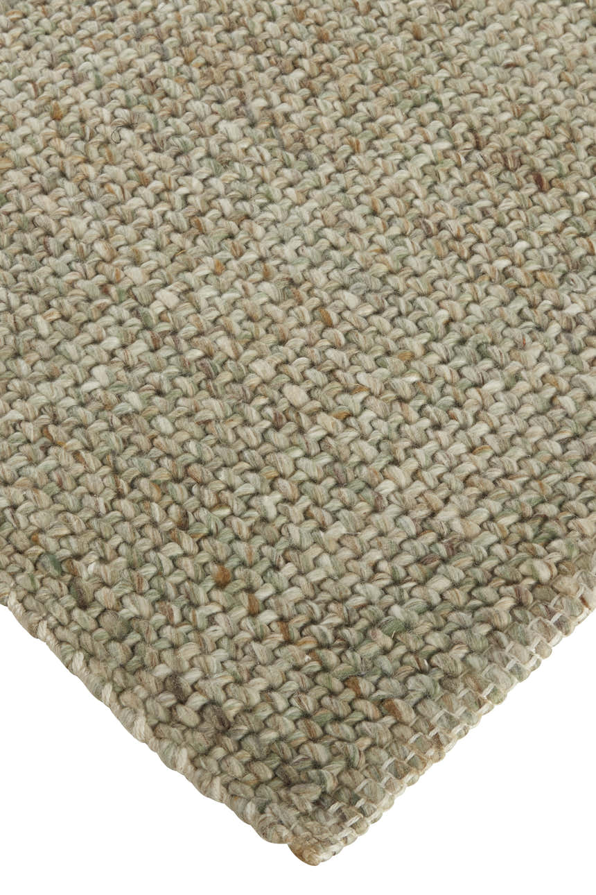 Close-up of the hand woven Feizy Naples Area Rug in green and tan, showing texture and detail. Corner