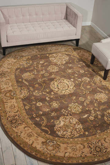 Living room scene with a Nourison 2000 Grey Persian rug, light pink sofa, and white chair on light wood floors.