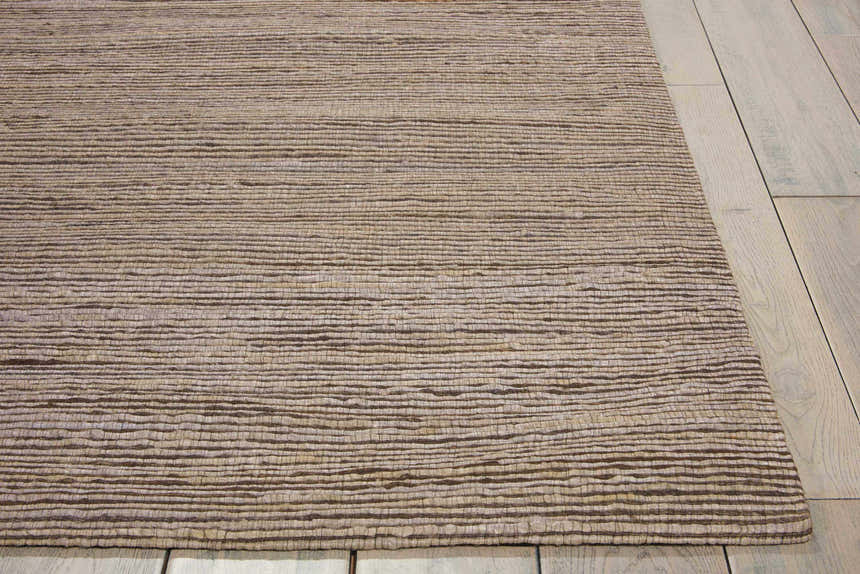 Close-up of the textured Calvin Klein Monsoon Loam rug. Handmade jute rug in neutral brown tones.