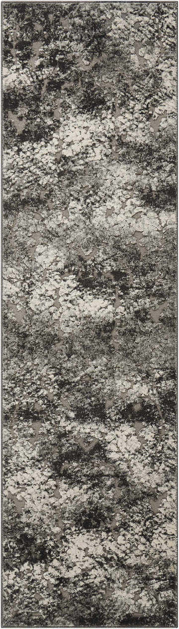 Close-up of the Michael Amini Gleam Ash rug. Modern design in ash, black, and gray with a distressed, abstract pattern.