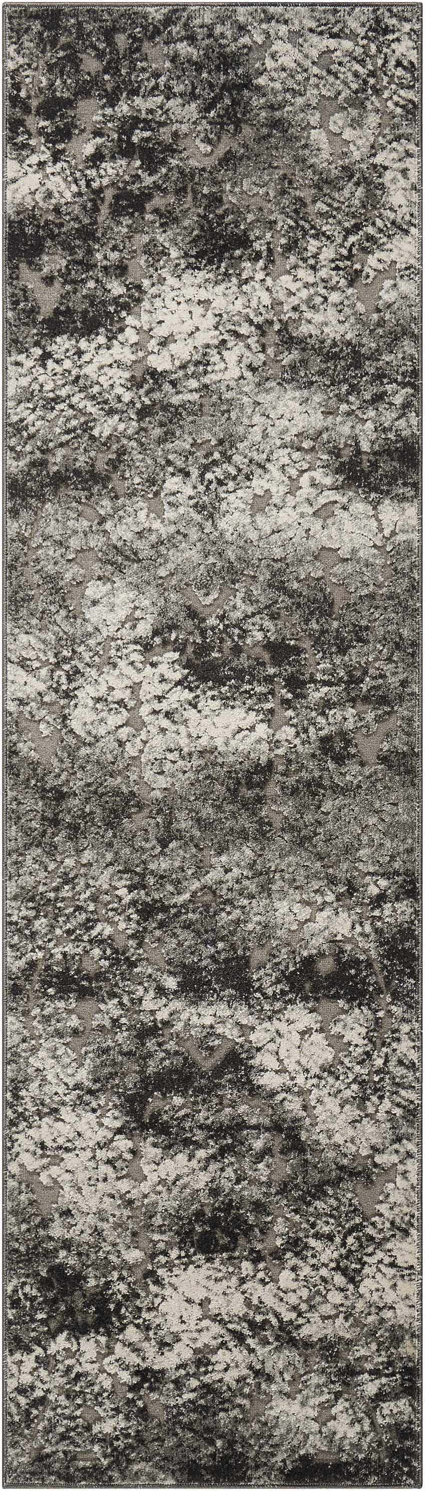 Close-up of the Michael Amini Gleam Ash rug. Modern design in ash, black, and gray with a distressed, abstract pattern.