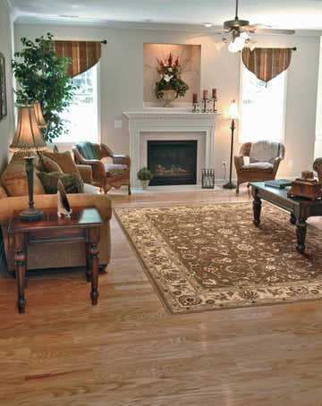 Living room scene with a Nourison Somerset Taupe rug, fireplace, sofa, and wood floors. Warm, inviting space.