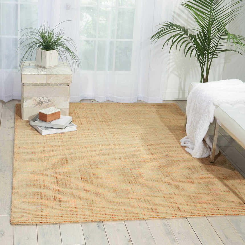 Light-filled room with a peach Barclay Butera Intermix Wheat rug, white bench, and plants.