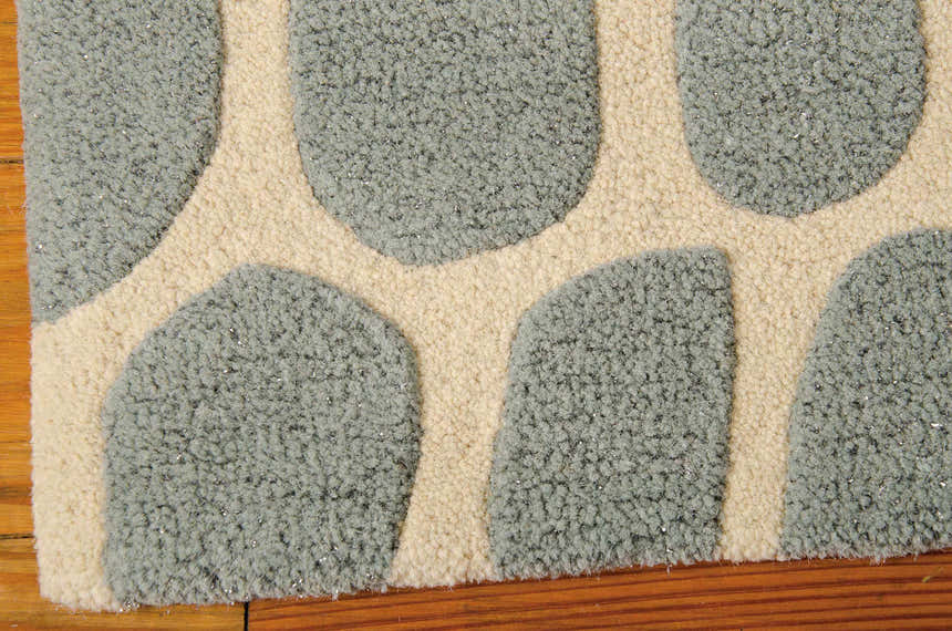 Close-up of the handmade Michael Amini Zambiana Aqua rug, showing its wool texture and eclectic aqua and cream pattern.