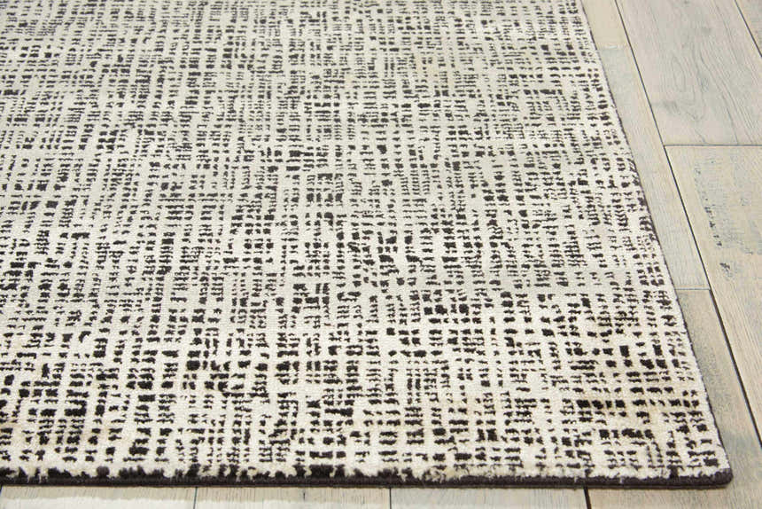 Close-up of Nourison Starlight Midnight rug showing its abstract black and ivory pattern and soft Luxcelle texture.
