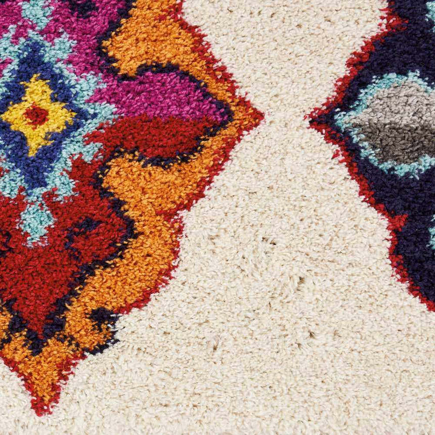 Close up of the Nourison Nomad Ivory Multicolor Floral rug showing texture and chestnut, red, and blue floral pattern.