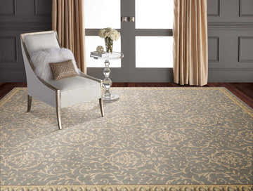 Elegant room scene with Nourison Riviera Blue Vintage rug, chair, glass table, and neutral drapes.