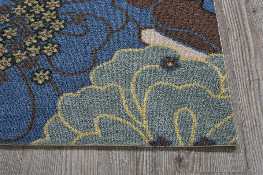 Close up of the Nourison Home & Garden Light Blue rug. Floral design in light blue, brown, and yellow. Machine-made texture.