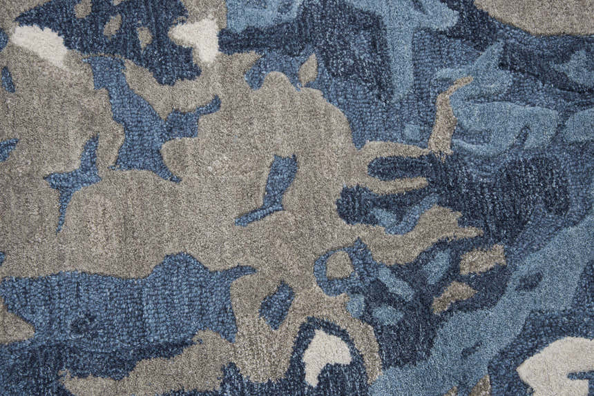 Close-up of the hand-tufted Rizzy MO867A area rug. Abstract pattern in beige, gray, navy, and taupe wool. Texture