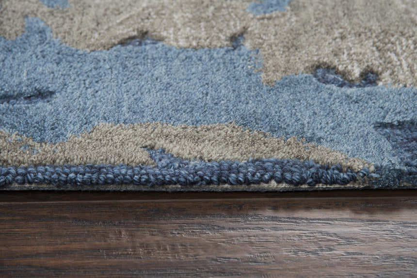 Close up of the hand-tufted Rizzy MO867A area rug showing beige, gray, and navy wool texture and construction. Pile