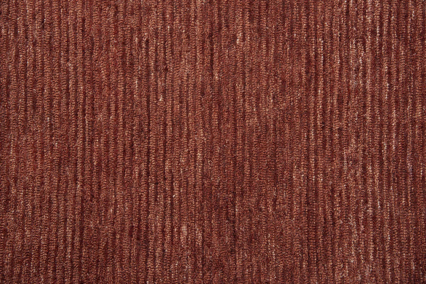 Close-up of the hand-tufted Rizzy MPK101 area rug. Dark red and rust recycled polyester with a casual, solid design. Texture