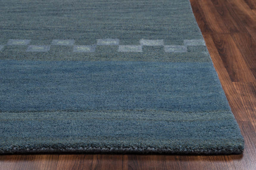 Close-up of the blue Rizzy MV3161 area rug showing the hand-tufted texture and farmhouse-style stripe and checkerboard pattern. Corner