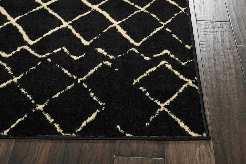 Close up of the Nourison Grafix Black Bohemian Indoor Area Rug showing its black and ivory geometric design.