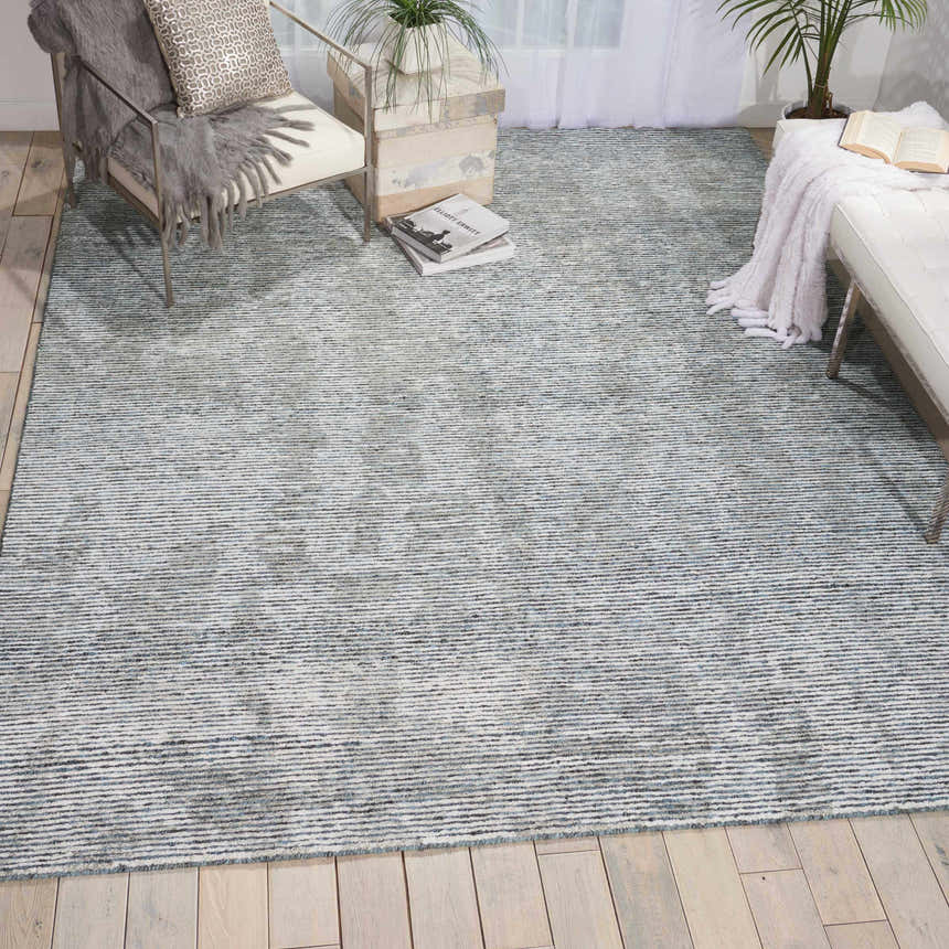 Modern living room with taupe Nourison Ellora Slate rug, light wood floors, white furniture, and natural light.