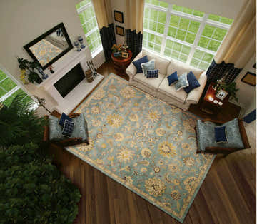 Living room with a Nourison Jaipur Light Blue Persian rug, white sofa, fireplace, and wood floors.