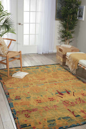 Bright living room with Nourison Dune Gabbeh Persian rug, wood chair, bench, and plants.