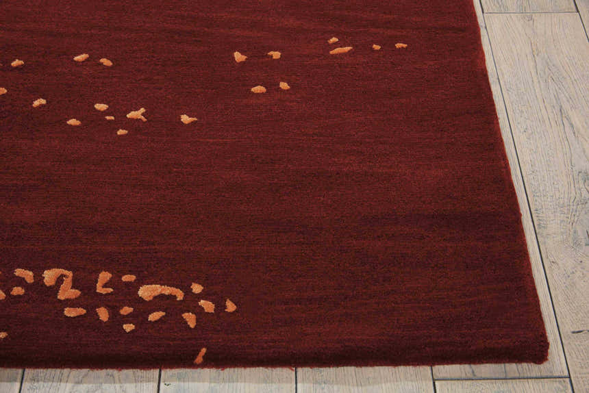 Close-up of the Nourison Opaline Fire Vintage rug, showing its deep red color and abstract orange pattern.