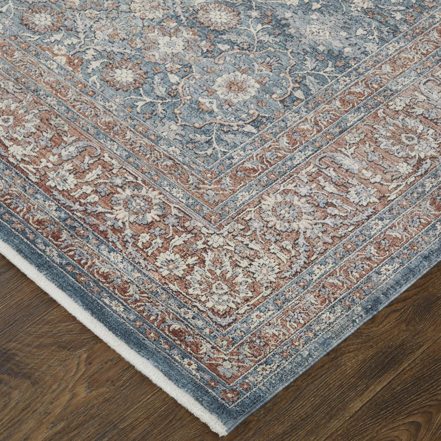 Close up of Feizy Marquette rug, showing blue, red, and cream floral oriental pattern on dark wood floor. Corner