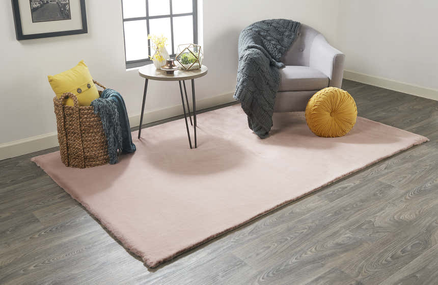 Living room scene with a Feizy Luxe Velour Modern Solid Pink Area Rug, gray chair, wood floors, and yellow accents. Roomscene-Rectangle