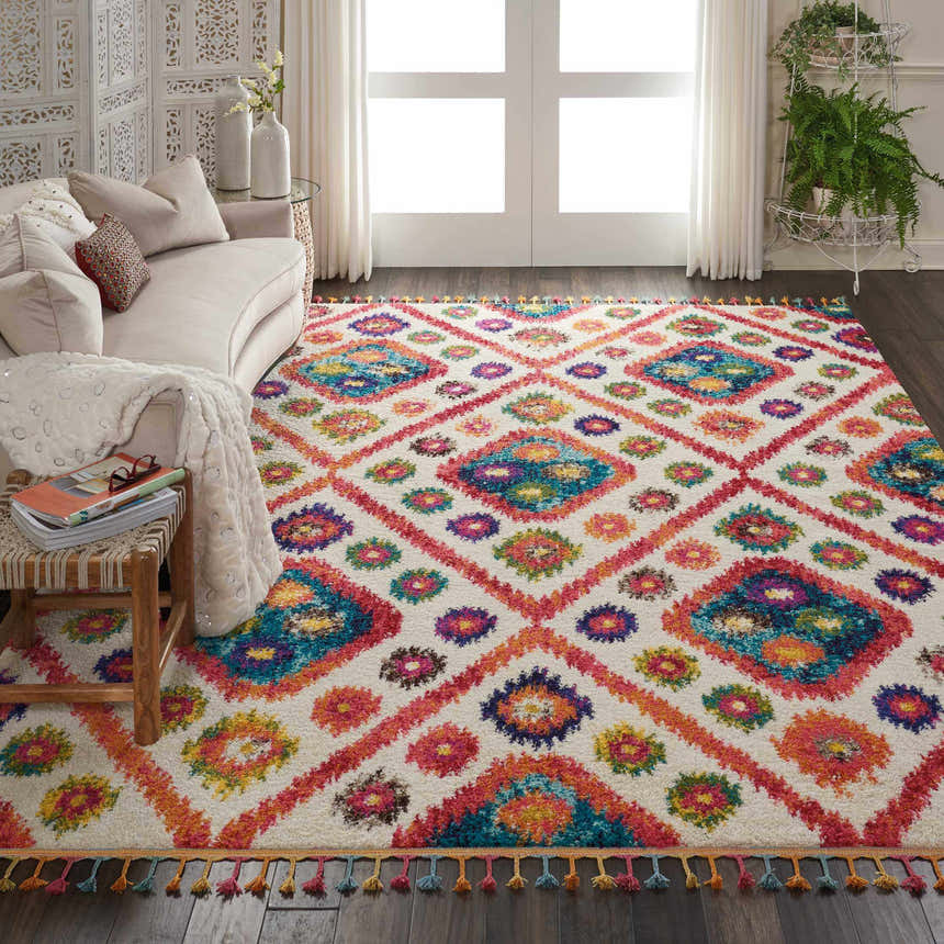 Living room scene with a Nourison Nomad Ivory Pink Tribal rug, sofa, and natural light.