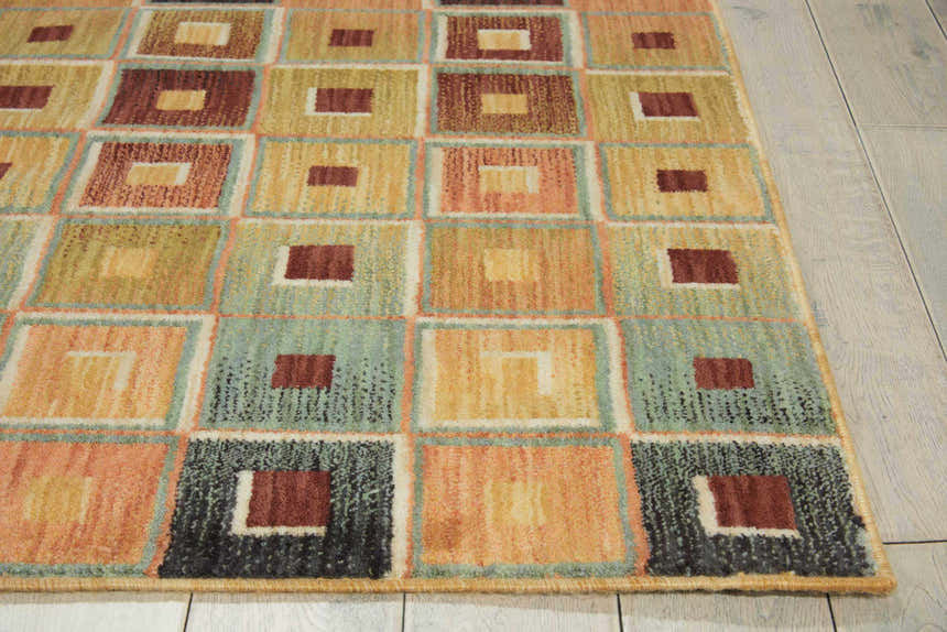 Close-up of the Nourison Aristo Multicolor Indoor Area Rug, featuring a geometric square pattern in shades of brown, gold, green, and peach.