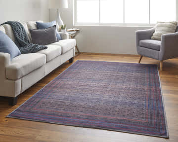 Living room scene with Feizy Voss Transitional Distressed rug in blue, pink, and purple. Sofa, chair, and wood floors. Roomscene-Rectangle