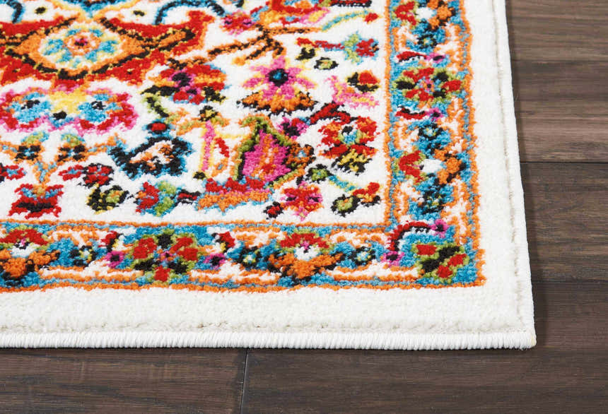 Close-up of Nourison Oakdale Ivory Vintage rug showing colorful floral pattern and soft texture on dark wood floor.