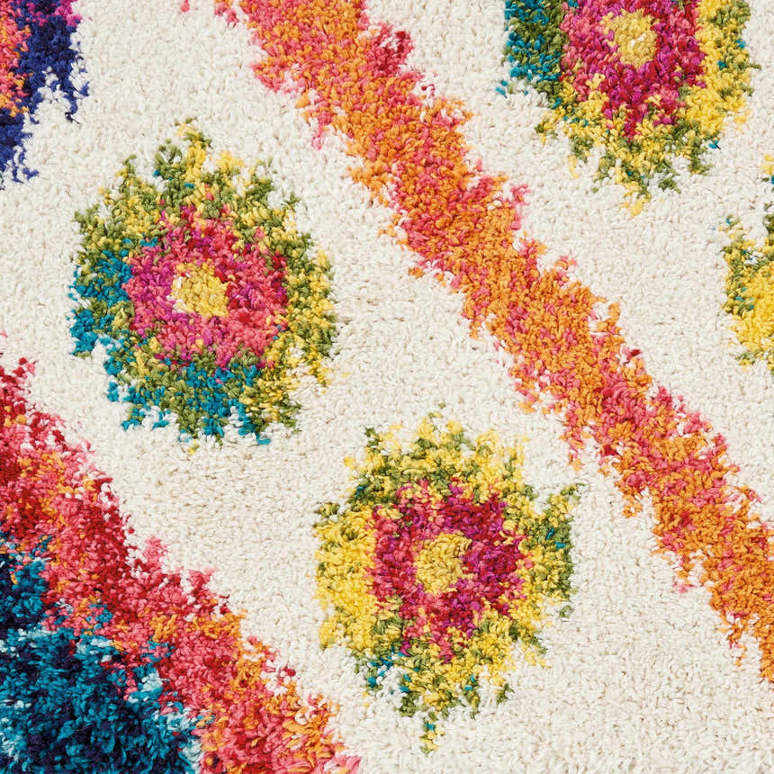 Close-up of Nourison Nomad Ivory Pink Tribal Rug. Features floral and striped patterns in pink, orange, blue, and yellow.