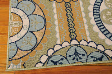 Close up of the Nourison Caribbean Yellow rug, featuring a blue, yellow, and white floral pattern.