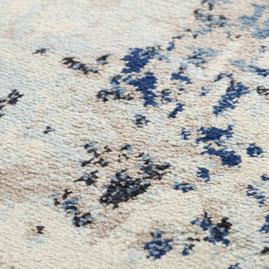 Close-up of the Rizzy PLC855 area rug. Abstract design in beige, black, blue, and ivory. Power-loomed texture. Texture