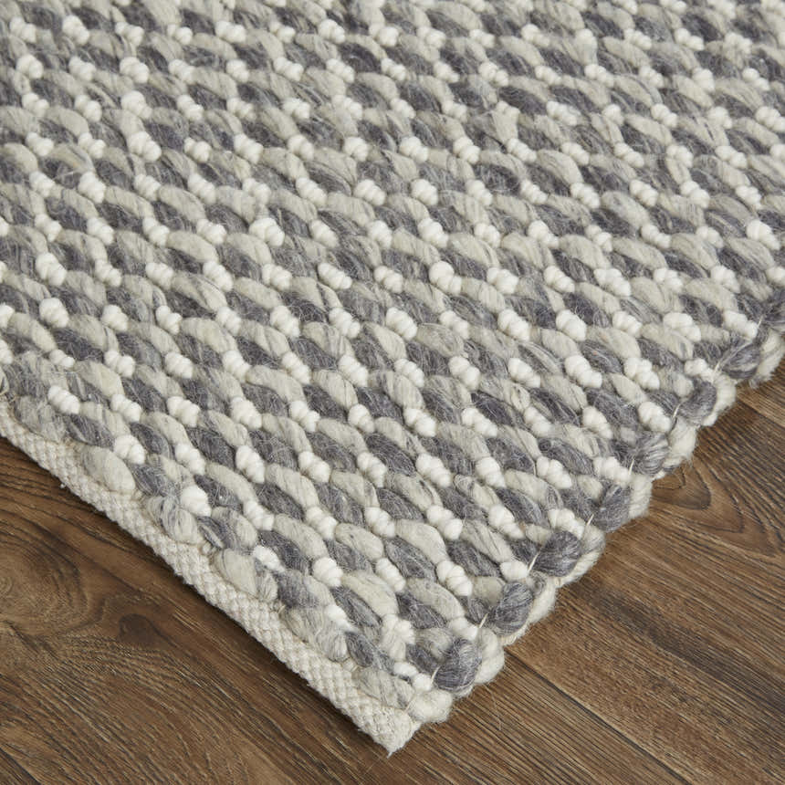 Close-up of the Feizy Berkeley rug in gray and ivory. Hand-woven wool rug with a textured, transitional design. Corner