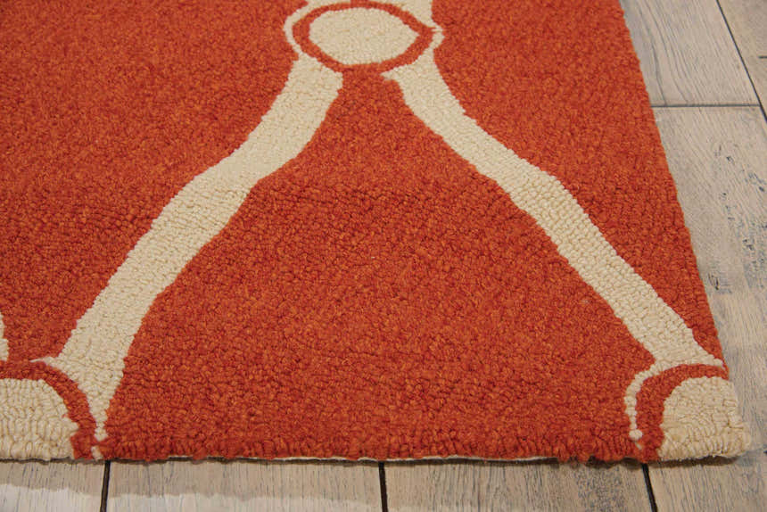 Close up of the Nourison Portico Orange Colorful Area Rug, featuring a burnt orange shag texture and cream geometric pattern.
