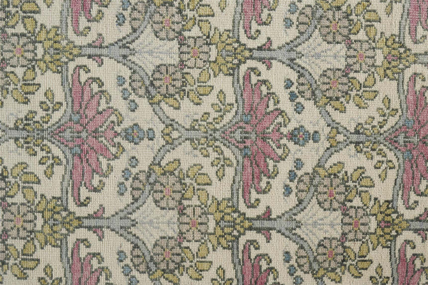 Close-up of the Feizy Beall rug: ivory wool with a pink and green floral and botanical hand-knotted traditional design. Texture