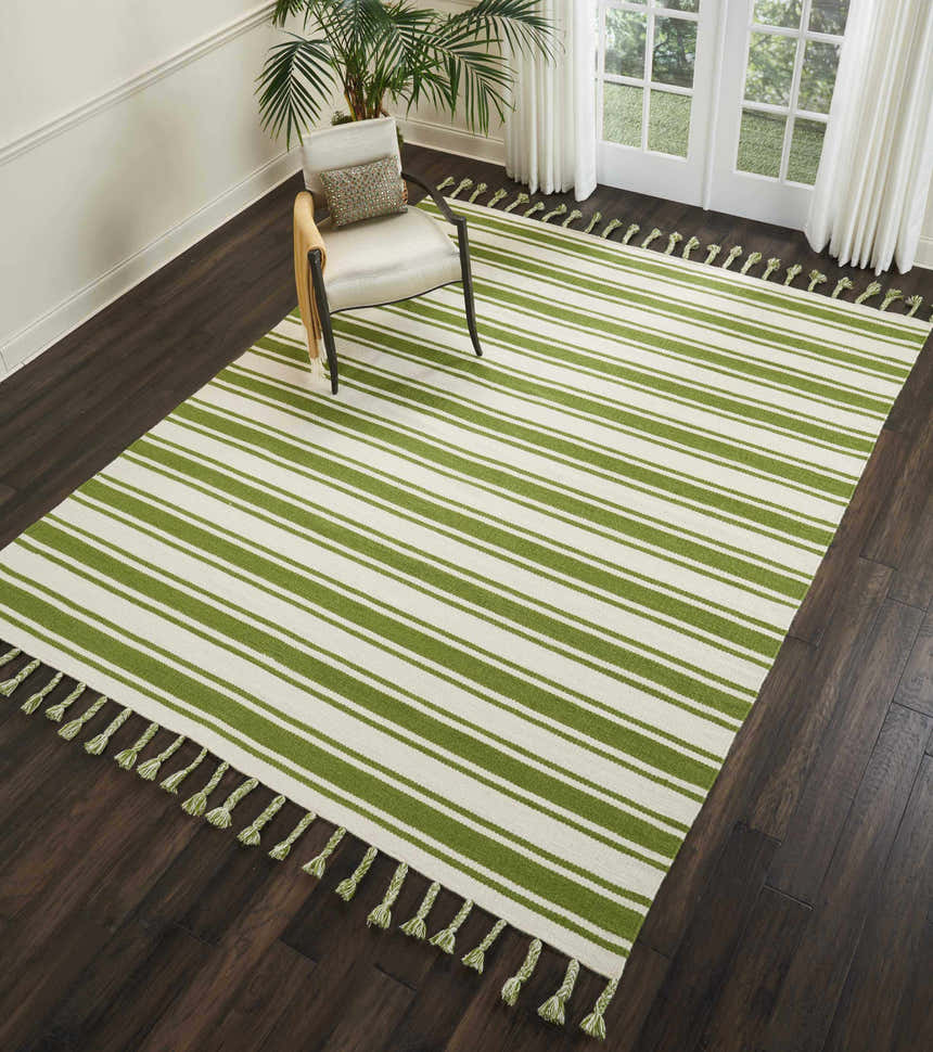 Living room scene with Nourison Rio Vista ivory and green striped rug, chair, dark wood floors, and natural light.