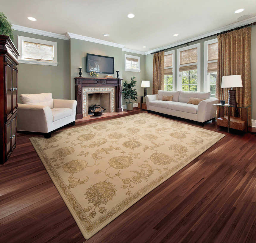 Living room with sandstone Nourison Regal Persian rug, white sofa and armchair, fireplace, and hardwood floors.