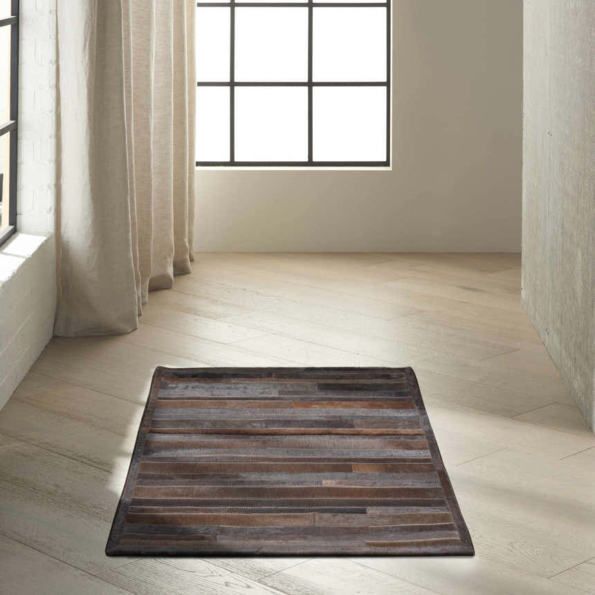 Minimalist room with a Calvin Klein Home Prairie Sable rug on light wood floors.