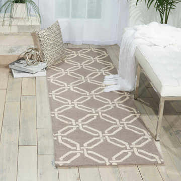 Entryway with Nourison Linear Silver rug, geometric pattern. Runner rug on light wood floor, bench, pillow, and plants.